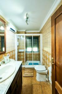 ein Badezimmer mit Toilette, Waschbecken und Dusche in der Unterkunft Vivienda Turística La Huerta in Guadalcanal