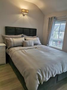 a large bed in a bedroom with a window at Modern 3-Bed Apartment in Magherafelt Sleeps 8 in Magherafelt