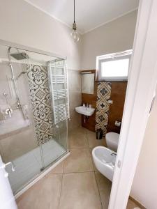 ein Bad mit einer Dusche, einem WC und einem Waschbecken in der Unterkunft Crialesi Boutique Rooms in Falerna