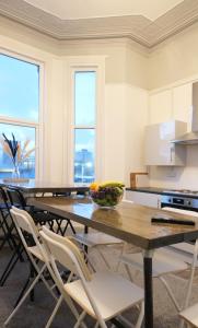 a kitchen with a table with chairs and a bowl of fruit on it at Windham ApartHotel by Serviced Living Liverpool in Litherland