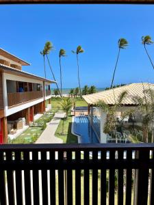 een uitzicht op een resort met palmbomen en een zwembad bij Apto novo Imperia Lounge pé-na-areia Itacimirim in Itacimirim