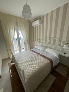 a bedroom with a white bed and a window at Crialesi Boutique Rooms in Falerna +14 photos