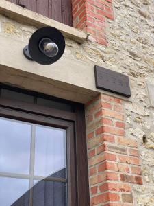 a bird sitting on the side of a building with a window at Gîte à la campagne 1 in Sainteny