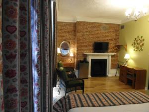 a bedroom with a bed and a living room with a fireplace at Hôtel Manoir de l'Esplanade in Quebec City