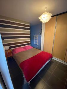 a bedroom with a large bed with a red blanket at Gîte à la campagne 1 in Sainteny