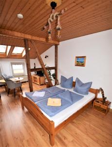 Schlafzimmer mit einem Bett mit Holzdecke in der Unterkunft Siggis Pension - Apartments in Ostseebad Sellin
