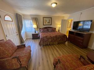 a bedroom with two beds and a flat screen tv at Rainbow Lodge and Inn in Colorado Springs