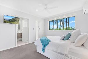 a white bedroom with a large bed and a window at Mala Retreat Chardonnay Studio Immaculate and Comfortable in East Maitland