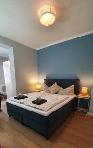 1 dormitorio con 1 cama grande y pared azul en heinrichs 4a, en Norderney