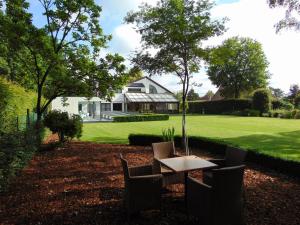 een tafel en stoelen voor een huis bij Alury B&B in Heusden - Zolder