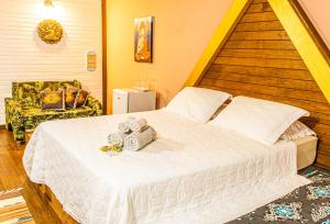 a bedroom with a white bed with towels on it at Pousada Casa do Oscar in Governador Celso Ramos