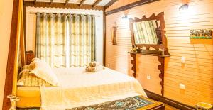 a bedroom with a bed and a large mirror at Pousada Casa do Oscar in Governador Celso Ramos