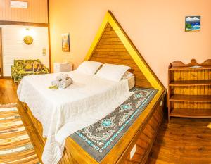 um quarto com uma cama grande e uma cabeceira em madeira em Pousada Casa do Oscar em Governador Celso Ramos