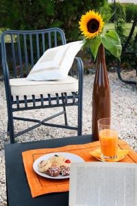 a vase with a sunflower and a plate of food on a table at Alla Corte Del Picchio Room & Breakfast in Castel Guelfo di Bologna