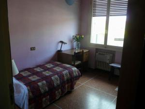 a bedroom with a bed and a desk and a window at Hotel Triana e Tyche in Sasso Marconi