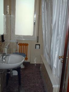 bagno con lavandino e tenda doccia di Hotel Triana e Tyche a Sasso Marconi