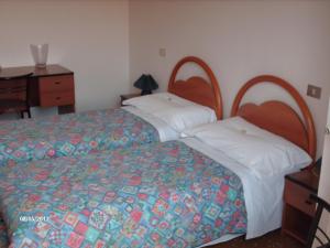 a bedroom with two beds and a dresser and a desk at Hotel Triana e Tyche in Sasso Marconi +19 photos