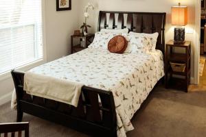 a bedroom with a large bed with a wooden headboard at The Nest in 5 Points, Downtown, Walk to Everything in Huntsville