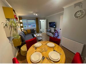 a living room with a wooden table and red chairs at Highfield apartment in Inverness