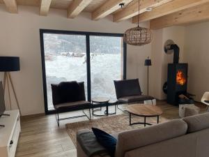 a living room with a couch and chairs and a large window at Luxury Chalet Mauthner Alm in Kötschach