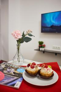 uma mesa com um prato de doces e um vaso com flores em RV Old City Apartment Velyka Vasylkivska,28 em Kiev