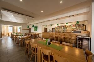 restauracja z drewnianymi stołami i krzesłami oraz bar w obiekcie Na Zeleném statku w mieście Rašovice