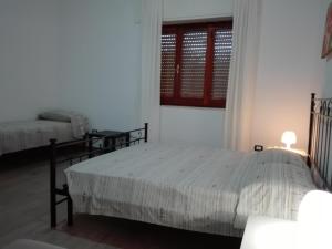 a bedroom with two beds and a window at B & B La Magnolia in Specchiolla