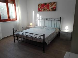 a bed in a bedroom with two night stands and two lamps at B & B La Magnolia in Specchiolla