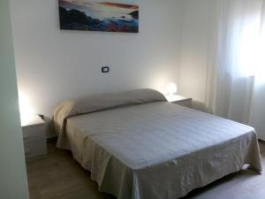 a bedroom with a bed and a painting on the wall at B & B La Magnolia in Specchiolla