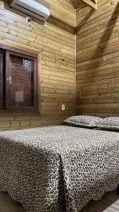 um quarto com 2 camas num quarto de madeira em Cabana Refúgio canyon Malacara em Praia Grande