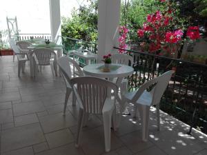 a row of tables and chairs on a balcony with flowers at B & B La Magnolia in Specchiolla