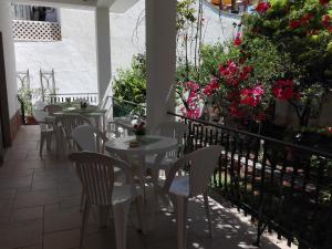 a patio with white tables and chairs and flowers at B & B La Magnolia in Specchiolla