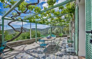 d'une terrasse avec une table et des chaises et une vue sur les montagnes. dans l'établissement Beautiful stone house in the village of Poggio-di-Nazza, à Poggio-di-Nazza