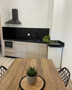 una cocina con una mesa de madera con una maceta. en Apartamentos Casa Anselmo EL TERRAO 