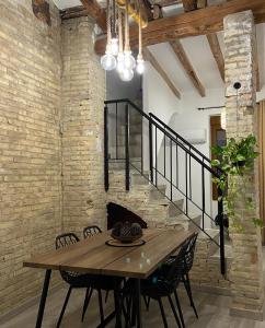 a dining room with a wooden table and a brick wall at Apartamentos Casa Anselmo EL TERRAO 