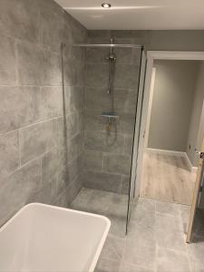 a bathroom with a shower and a bath tub at Immaculate 2-Bed Bungalow in Snettisham in Snettisham