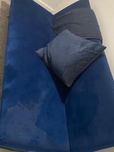 a blue bed with a black pillow on it at Stylish & Convenient in Belfast