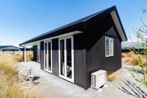 a black house with windows and a heater on a patio at Mountain Vista Retreat - Apartment 1 in Twizel