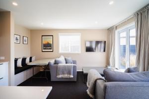 uma sala de estar com um sofá e uma mesa em Mountain Vista Retreat - Apartment 1 em Twizel