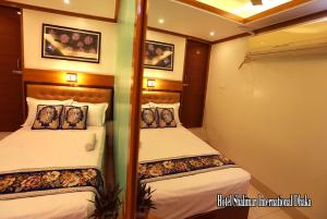 een slaapkamer met 2 bedden op een jacht bij Hotel Shalimar Motijheel - Centre of City in Dhaka