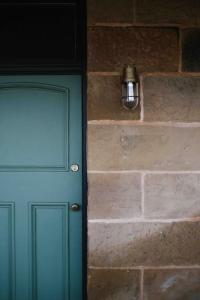 a green door with a light next to a brick wall at Raffah House in Oatlands