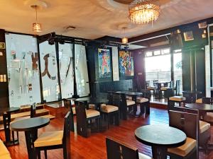a dining room with tables and chairs and windows at Hotel Mary Celaya in Celaya