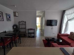 sala de estar con sofá rojo y mesa en Departamento Maipu 501, en Coquimbo