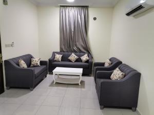 a living room with two couches and a table at Al Basam Furnished Units in Yanbu