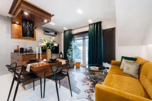 a living room with a yellow couch and a table at Bed&Bath Luxury Apartments in Krakow