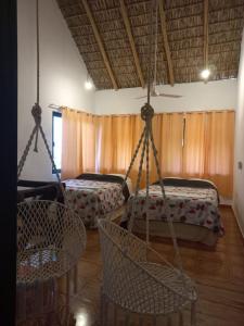 um quarto com dois baloiços e uma cama em Villa del Mar em Zipolite