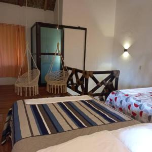 um quarto com 2 camas e 2 baloiços em Villa del Mar em Zipolite
