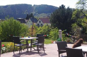 un patio con mesa y sillas en un jardín en Hinter den Spiegeln en Heimbach