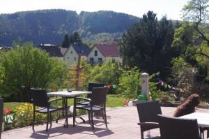 a patio with a table and chairs in a garden at Hinter den Spiegeln in Heimbach