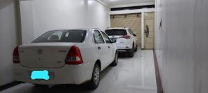 two parked cars parked in a garage with a car sticker on the back at Departamento KIRI familiar ó empresarial cerca al Aeropuerto de Juliaca- Perú in Juliaca